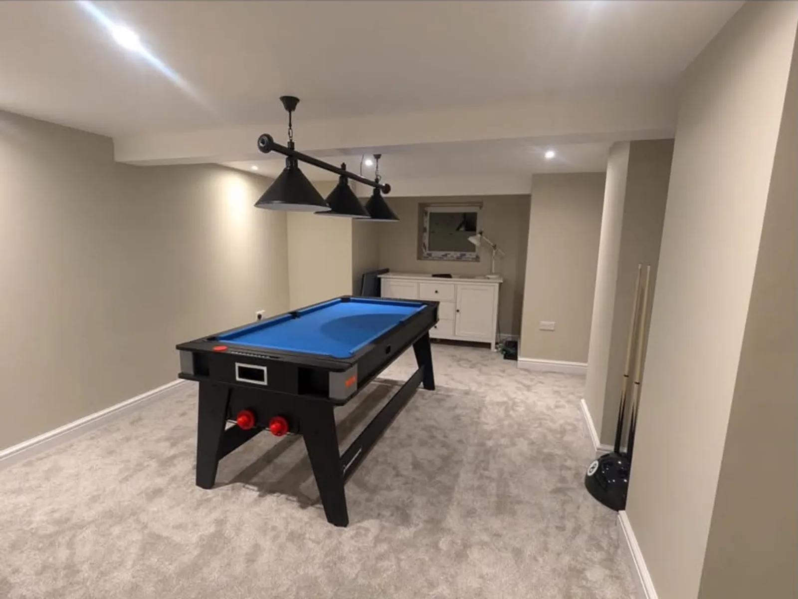 Finished basement games room with pool table, pendant lighting and fitted carpet after conversion