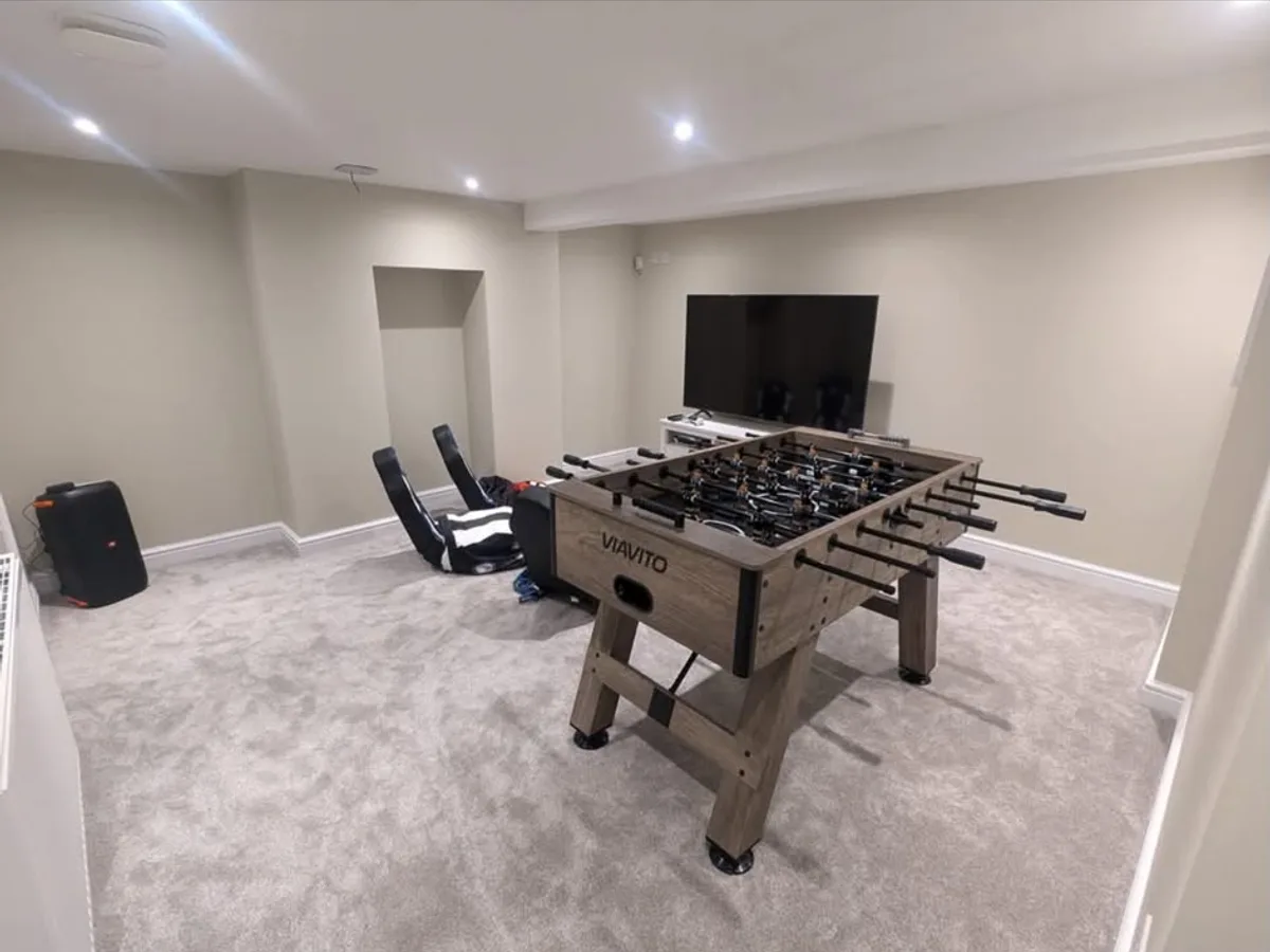 Finished Selby basement games room with football table, wall-mounted television and fitted carpet