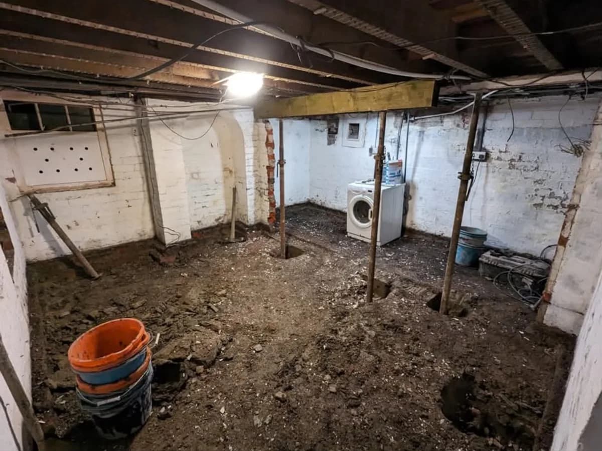 Selby cellar mid-conversion with dug-out earth floor, acrow props and exposed brickwork