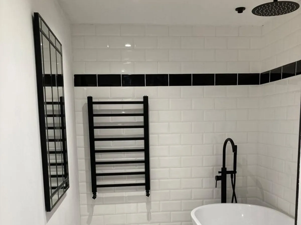 Finished Shipley basement bathroom with metro tiling, freestanding bath and black heated towel rail
