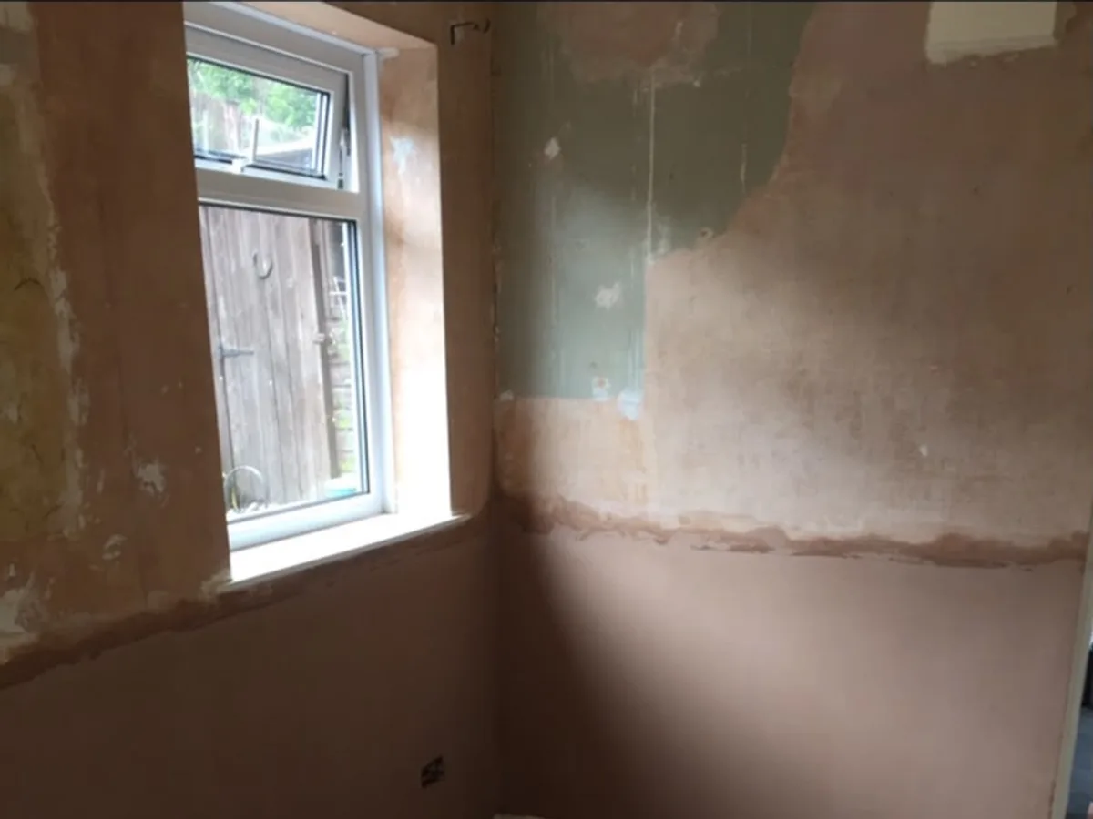 Wall hacked back to brick at low level during rising damp works, showing the salt tide mark left by ground moisture